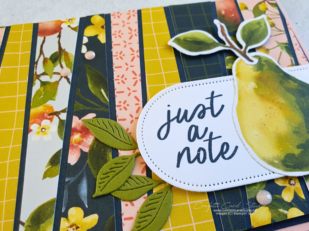 Handmade card close up of the scrappy strip technique and the decoration of a pear and the sentiment just a note.