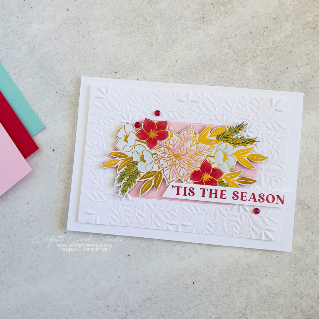 Handmade card using traditions of Christmas designer series paper as the focal point. The card base is white with a white layer embossed with leaves. The sentiment is 'tis the season.