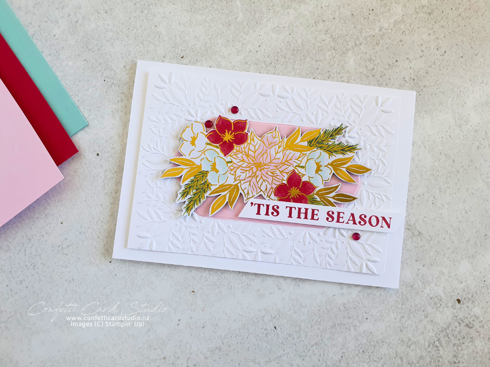 Handmade card using traditions of Christmas designer series paper as the focal point. The card base is white with a white layer embossed with leaves. The sentiment is 'tis the season.