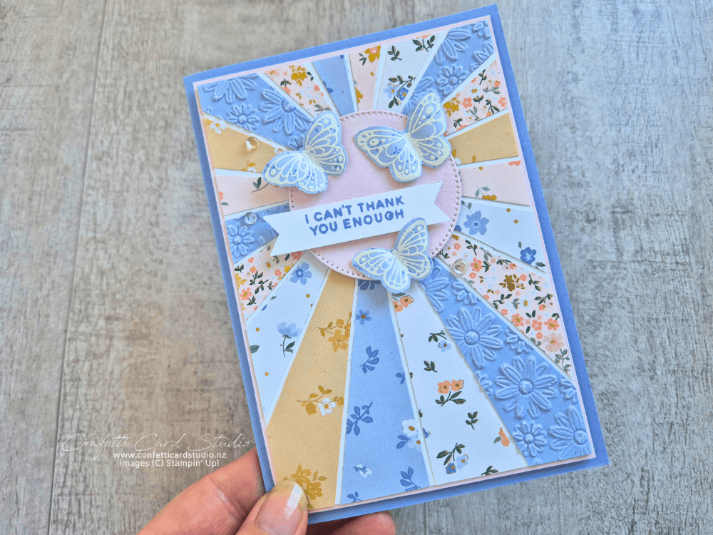 Handmade card featuring a sunburst background created with Bloom Boutique Designer Series Paper, embossed Hydrangea Hue cardstock, and white embossed butterflies.