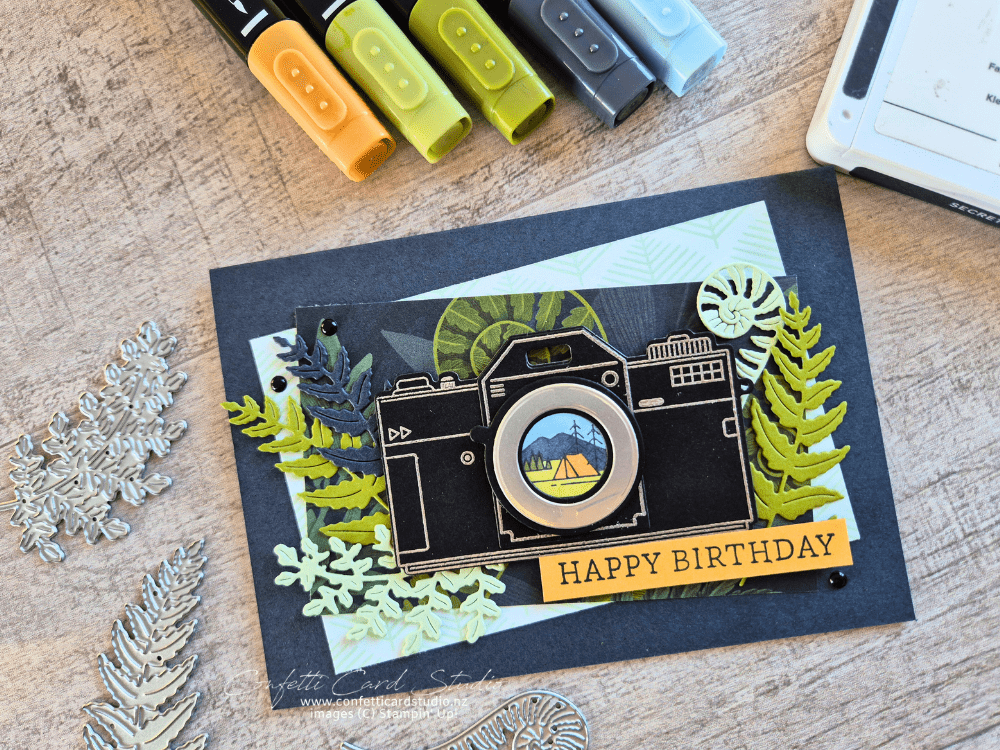 Handmade masculine camera birthday card with a black and silver camera, Moonlit Flora Designer Series Paper, camping scene, foliage, and Happy Birthday greeting.