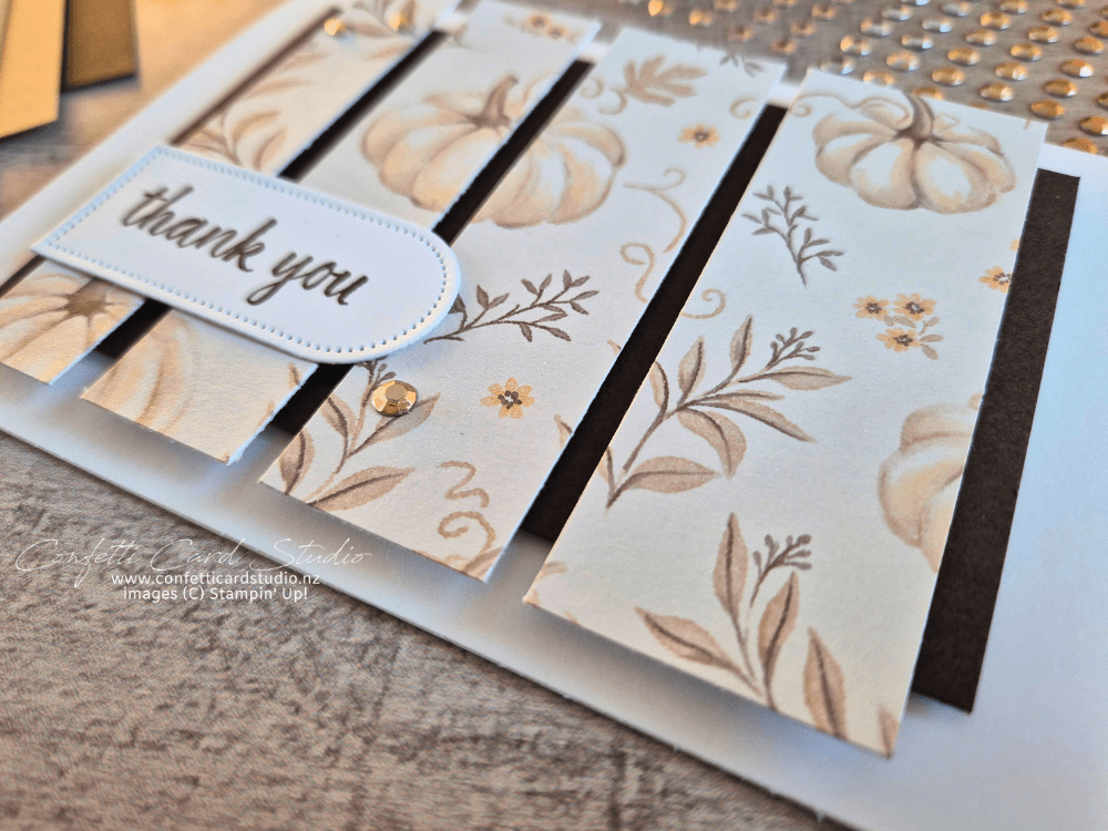 Close up of simple Designer Series Paper sketch card with four vertical strips of pumpkin-themed DSP and a thank you sentiment.